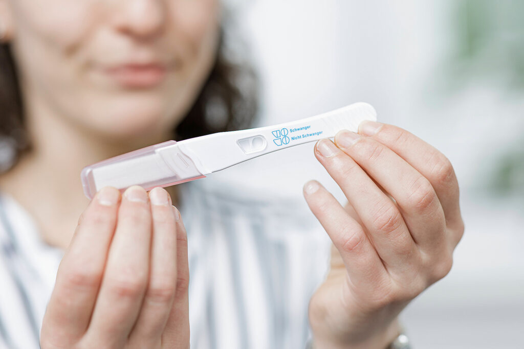 Foto: Schwangerschaftsberatung - Frau hält Schwangerschaftstest