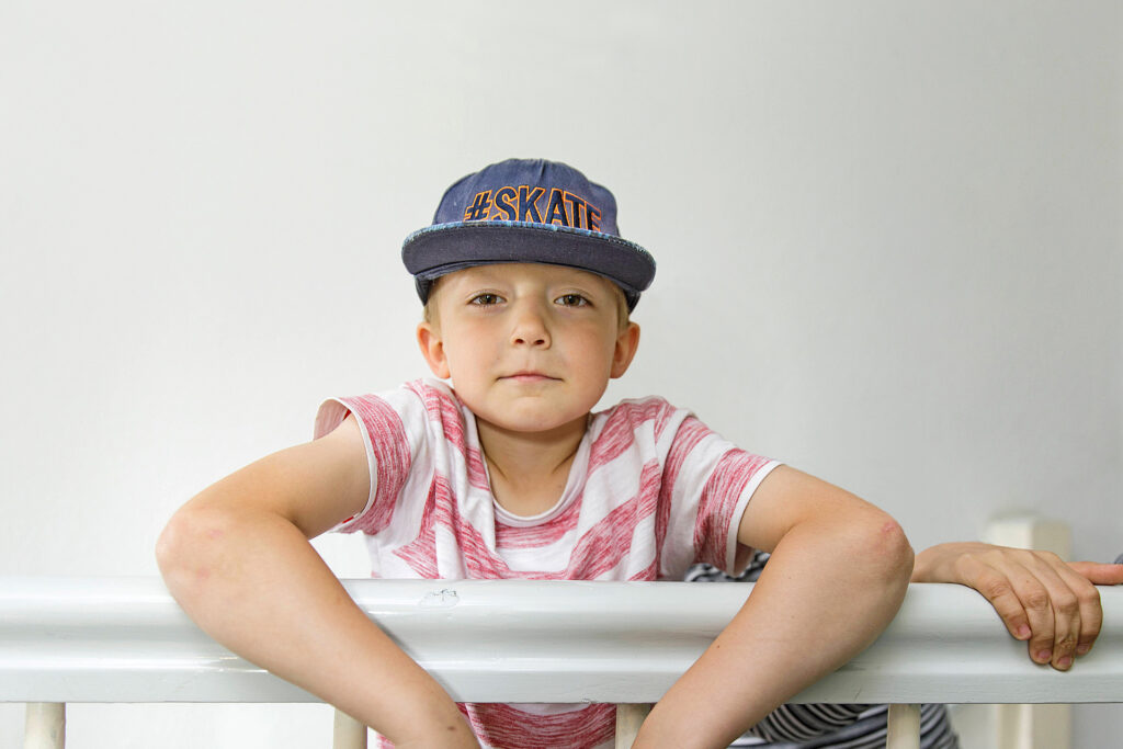 Foto: Kind mit Cap lehnt über Treppengeländer - Erziehungshilfen Diakonie Münster