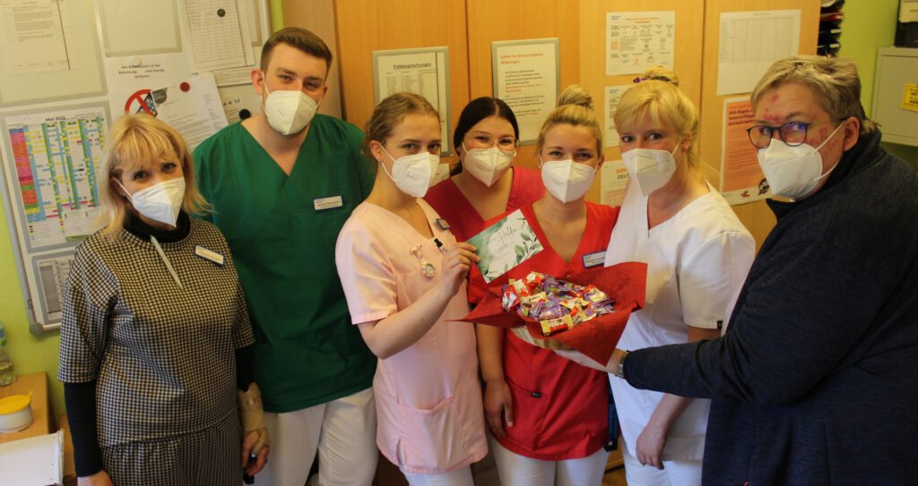 Foto: Einrichtungsleitung Iris Würthele verteilt Süßigkeiten an ihre Mitarbeitenden