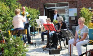Foto: Einrichtungsleiter Thorsten Kloster überreicht Blumen an die Musikerinnen